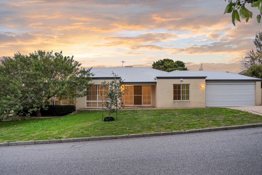 Single-storey home at dusk with a lit front room